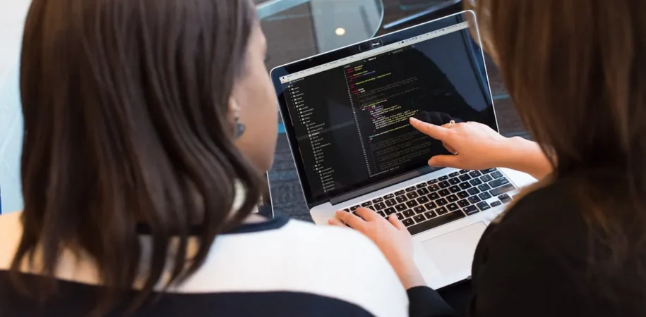 Software automation engineers collaborating on test scripts and CI/CD pipeline integration in a tech workspace.