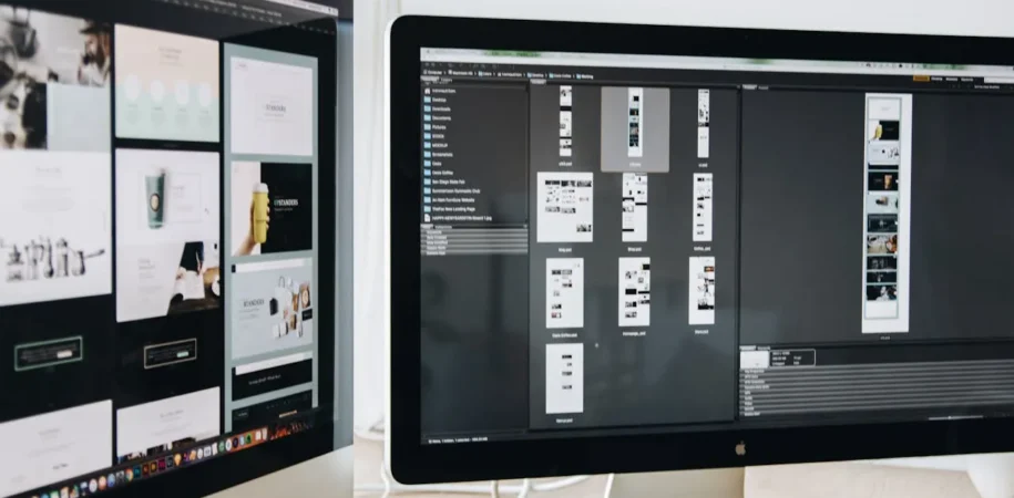 Two monitors displaying different website template designs side by side